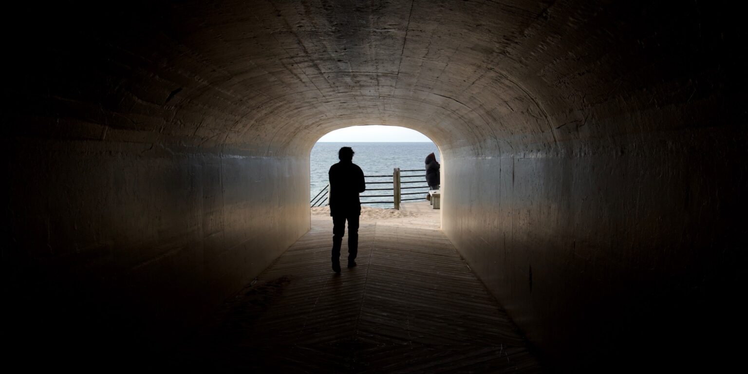 SEO process step 4, commercial insight: silhouette walking toward light at the end of a tunnel