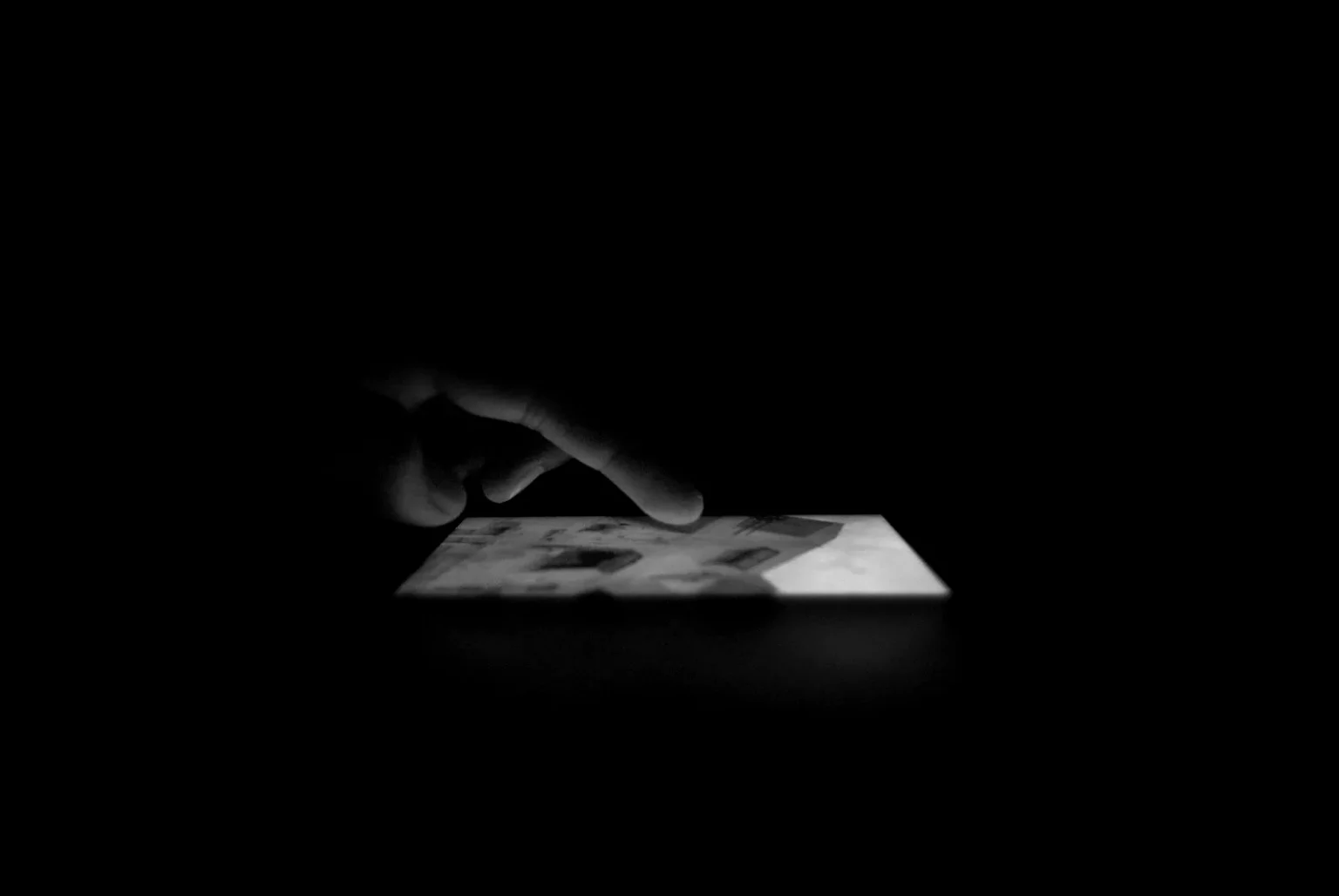 Hand holding a glowing phone in the dark
